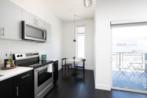 a kitchen with a stove top oven next to a window at Flexhome Skywalk to Fiserv 1BR Apt U6 - READ INFO in Milwaukee