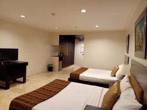 a hotel room with two beds and a television at Paragon Tower Hotel in Manila