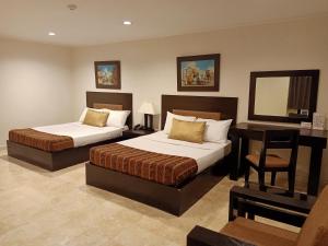 1 dormitorio con 2 camas, escritorio y espejo en Paragon Tower Hotel en Manila