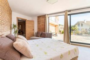 a bedroom with a bed and a large window at Villa Sentiu. Hermoso chalet in Gavà