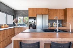 a kitchen with wooden cabinets and a large kitchen island at Villa Sentiu. Hermoso chalet in Gavà