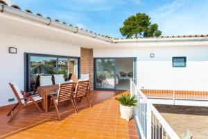 un balcone con tavolo e sedie su una casa di Villa Sentiu. Hermoso chalet a Gavà