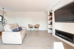 a living room with a white couch and a flat screen tv at Villa Sentiu. Hermoso chalet in Gavà