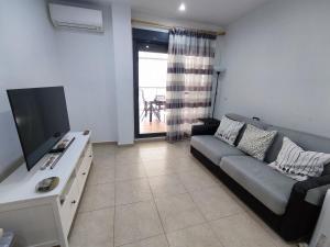 sala de estar con sofá y TV de pantalla plana en Acogedor apartamento cerca de la playa, en Moncófar