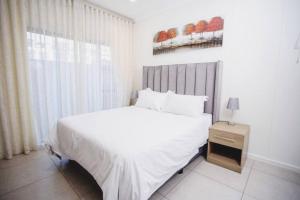 una camera con un letto bianco e una finestra di Lovely morden 1 bedroom cozy apartment a Lombardy East