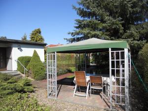 a gazebo with a table and chairs under it at Ferienhaus Vorwachs 1 in Schwielochsee