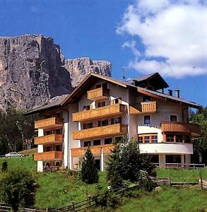 a large building in front of a mountain at Pensione Sellablick in Colfosco