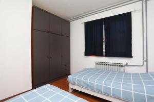 een slaapkamer met een blauw bed en een raam bij Apartment Rozman in Vozilići