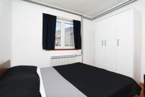 een slaapkamer met een zwart-wit bed en een raam bij Apartment Rozman in Vozilići