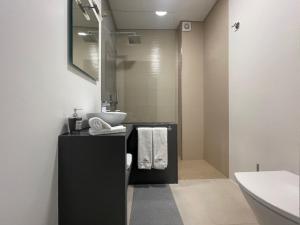 een badkamer met een wastafel en een spiegel bij PORTA NOVA Historic Center - Apartments Collection by Perpetual Relax in Braga