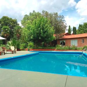 una piscina frente a una casa en Libertad Posada y Spa en Villa Las Rosas