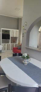 a living room with a white table with a vase of flowers at Estía Holidays Apartments - Taormina in Taormina