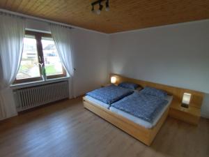a bedroom with a bed and two windows at Adenauer Cottage in Adenau