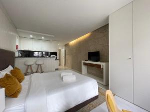 a bedroom with a white bed and a kitchen at PORTA NOVA Historic Center - Apartments Collection by Perpetual Relax in Braga