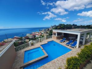 a house with a swimming pool and a view of the ocean at 2 minutes from Roseau, Cozy studio with shared pool in Roseau