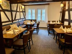 a restaurant with tables and chairs with napkins on them at Haus Wiesengrund in Hürtgenwald