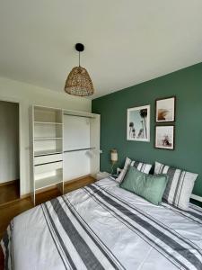 um quarto com uma cama grande e uma parede verde em L'Ocenoa2 em Mimizan