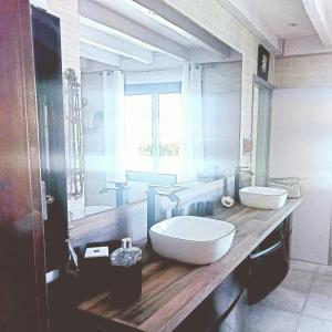 a bathroom with two sinks and a large mirror at VILLA Zaphira in Gujan-Mestras