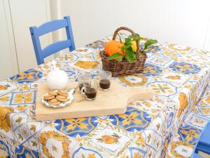 ピアノ・ディ・ソレントにあるIl giardino di aranci e limoniのクッキーのトレイとオレンジのバスケット付きのテーブル