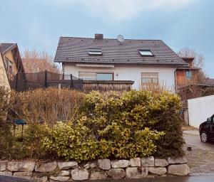 uma casa branca com uma cerca e alguns arbustos em FeWo Michistrasse em Forchheim