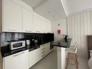 a kitchen with white cabinets and a microwave on a counter at PORTA NOVA Historic Center - Apartments Collection by Perpetual Relax in Braga