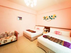 ein Hotelzimmer mit 2 Betten und einem Sofa in der Unterkunft Harbourview in Taitung