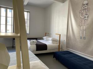 - une chambre avec 2 lits et une fresque murale représentant une femme dans l'établissement B&B Bloc G, à Carcassonne