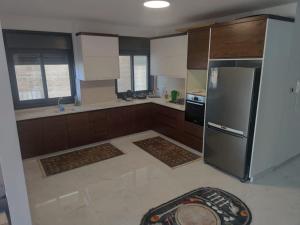 una cocina con nevera de acero inoxidable y armarios en Golden House en Ramallah