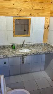 a bathroom with a sink and a window and a toilet at Casa Janjão in Icaraí