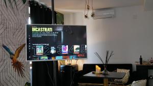 a large screen in a living room with a table at AN Deluxe Suites in Ancona