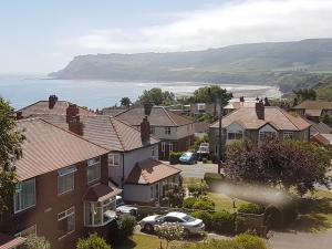 un grupo de casas en un barrio residencial con el océano en Church Holiday Apartments, en Robin Hood's Bay