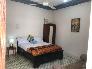 a bedroom with a bed and a ceiling fan at Anayah House in Kiembi Samaki