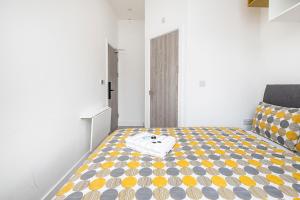 a bedroom with a bed with a yellow and gray pattern at Victorian Windowless Beauty with Private Bath Near Tube Station in London