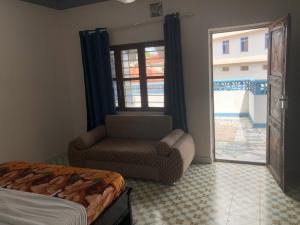1 dormitorio con 1 cama, 1 silla y 1 ventana en Anayah House, en Kiembi Samaki