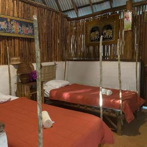 een slaapkamer met 2 stapelbedden met rode lakens bij Cabañas Maya Aire 