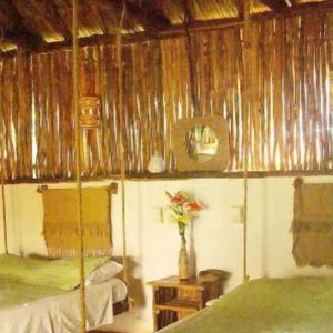 een kamer met 2 bedden en een vaas met bloemen erin bij Cabañas Maya Aire 