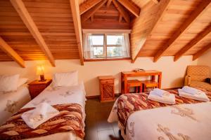 um quarto no sótão com duas camas e uma janela em Vientos del Sur em Pucón