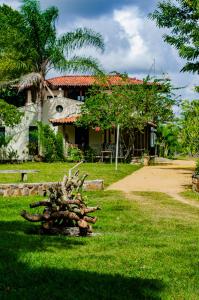 una casa con un montón de troncos en el césped en Fazenda Hotel Serra da Copioba, en Sobradinho