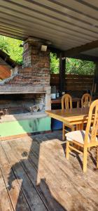 a wooden table and chairs on a patio with a fireplace at Casa en Ciudad de la Costa ideal para descanso in Ciudad de la Costa