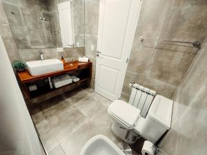 a bathroom with a white toilet and a sink at Destino Calafate in El Calafate +26 photos