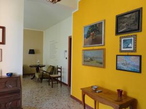 a room with a yellow wall with a table and chairs at La Villetta in Grottammare
