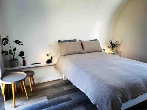 a bedroom with a large bed and a table and stool at The Grimsay Cabin in Carinish