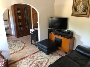 un soggiorno con TV, divano e sedia di Casa da Samouqueira a Rogil