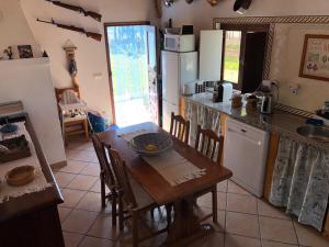 羅吉爾的住宿－Casa da Samouqueira，厨房配有带椅子和桌子的木桌,厨房配有
