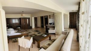 ein Wohnzimmer mit einem Bett und einem Sofa in der Unterkunft Hotel Royale in Galaţi