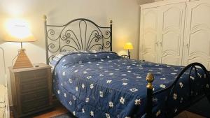 a bedroom with a bed with a blue comforter at QUINTA DO CAMBEIRO in Viana do Castelo