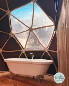 a bathroom with a window with a tub in a yurt at Little Wood Lodges Insolites in Bailly-aux-Forges