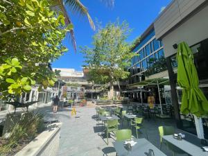 une cour avec des tables et des chaises dans un bâtiment dans l'établissement Key West Style Historic Home in Coconut Grove Florida, The Blue House, à Miami
