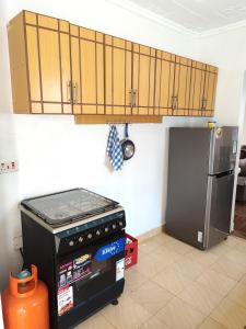 una cucina con piano cottura e frigorifero di Camp-Flo 3br Guest House-Eldoret a Eldoret