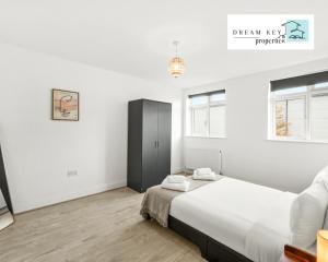 a white bedroom with a large bed and two windows at One Bedroom Apartment by Dream Key Properties Short Lets & Long Lets Uxbridge with Free Wi-fi - 5 in Uxbridge